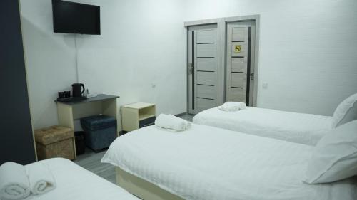 a hotel room with two beds and a television at Lotus Hotel in Yakkasaray