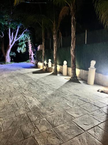 a walkway with palm trees and lights in a park at Villas de encanto in Vilamarxant