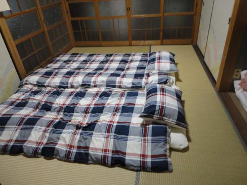 a bed with four pillows on it in a room at Ise Myojo no Yado - Vacation STAY 12556 in Saikū