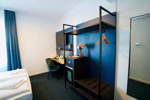 a room with a bed and a desk with a mirror at Arthotel Ambassador Wiesbaden - FREE PARKING in Wiesbaden