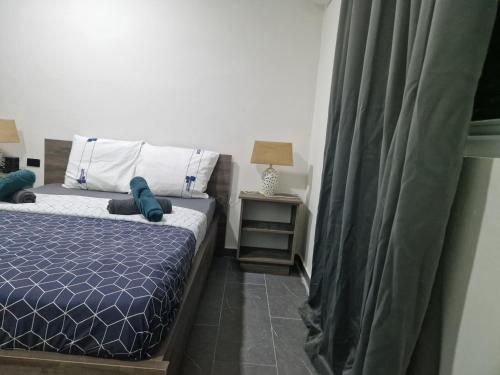 a bedroom with a bed and a night stand with a lamp at Casa Andries Montanja Rey in Willemstad