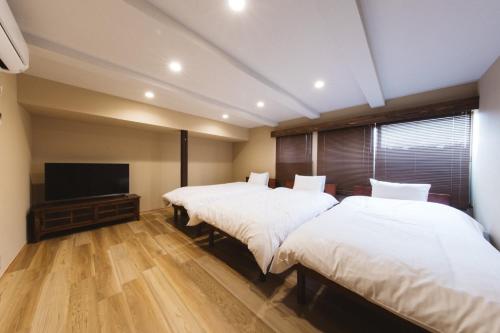 Un dormitorio con dos camas y un televisor de pantalla plana. en Large family accommodation Tsuji family - Vacation STAY 11311v, en Mitoyo