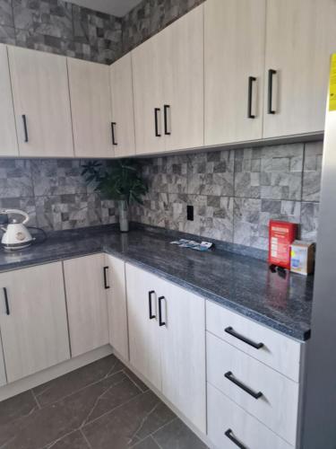 a kitchen with white cabinets and black counter tops at Casa Andries Montanja Rey in Willemstad