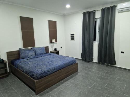 a bedroom with a bed with a blue comforter at Casa Andries Montanja Rey in Willemstad