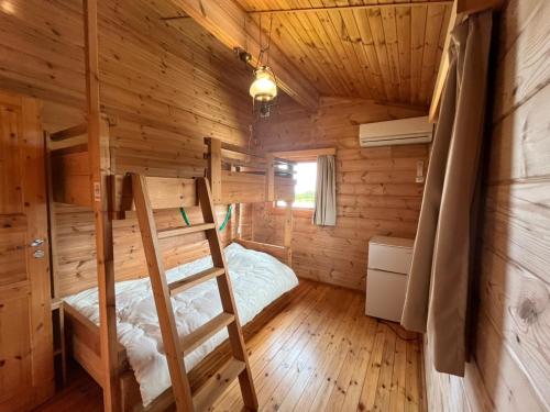 a bedroom with a bunk bed in a log cabin at Sesoko Log Cabin [Chimu lani] - Vacation STAY 26745v in Sesoko