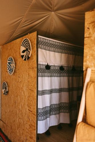 a room with a curtain in a tent at Caravansérail Agafay by Dar Inacamp in El Mjed