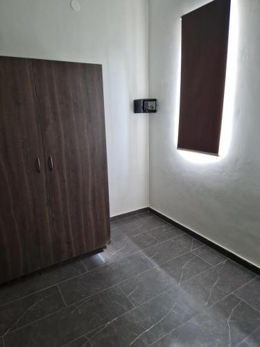 an empty room with a cabinet and a wall with a light at Casa Andries Montanja Rey in Willemstad