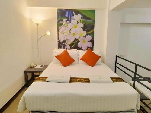 a bedroom with a bed with a painting on the wall at Siam Villa Suvarnabhumi in Ban Khlong Si