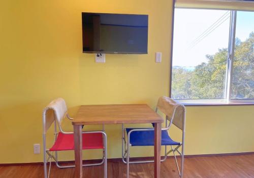 a table and chairs with a television on a wall at BLUE AMALFI - Vacation STAY 91483v in Ōbe