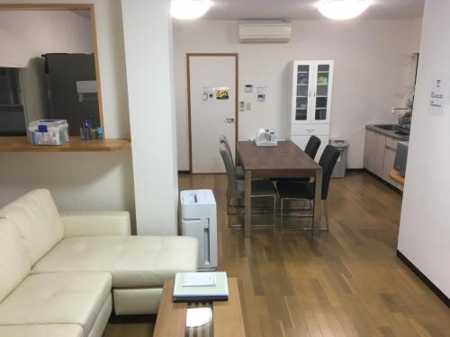 a living room with a couch and a table with chairs at HARBOR TERRACE RYUGATAKE - Vacation STAY 28730v in Takakushi