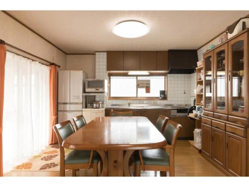 a kitchen with a wooden table and chairs at Yado wa Good Rich - Vacation STAY 30399v in Tokushima