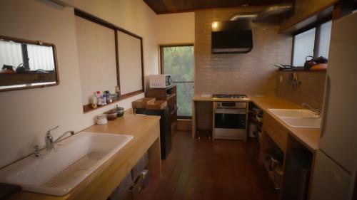 a large kitchen with two sinks and a stove at Maison d'hôtes KIRISIMIZU - Vacation STAY 40997v in Nagano
