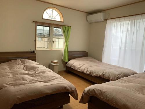 ŌteraにあるYado wa Good Rich Aizumi - Vacation STAY 30409vのベッド2台と窓のある寝室