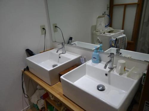a bathroom with two white sinks and a mirror at Minshuku Otaki fireplace - Vacation STAY 46344v in Miyaki