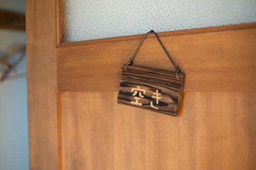 a wooden door with a sign hanging on it at CANOA GUEST HOUSE B room- Vacation STAY 47218v in Ikeda