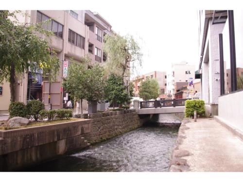 un fiume in una città con ponte e edifici di HOTEL APT SESELA - Vacation STAY 12883 a Kanazawa