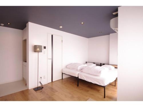 a bedroom with white walls and a bed with white pillows at HOTEL APT SESELA - Vacation STAY 12878 in Kanazawa