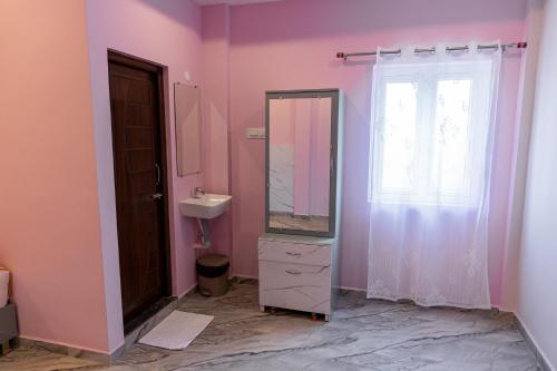 a bathroom with a mirror and a sink and a window at Pavan Vela Grand in Dindigul