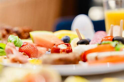 a plate of fruit and vegetables on a table at Arthotel Ambassador Wiesbaden - FREE PARKING in Wiesbaden