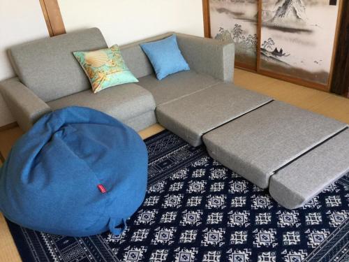 a living room with a couch and a blue bean bag at Lu Blue Sado SAWANE - Vacation STAY 12885 in Sado