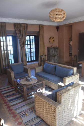 a living room with blue couches and a table at Domaine de l'Arganeraie in Ghazoua