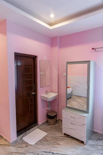 a bathroom with a sink and a mirror at Pavan Vela Grand in Dindigul