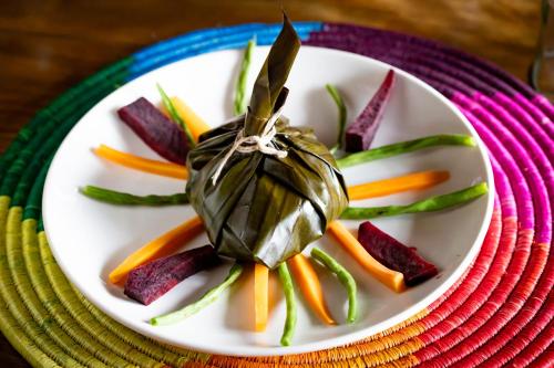 a plate of food with vegetables on a table at Chameleon Hill Forest Lodge in Bwindi