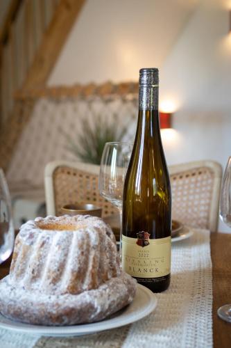 a bottle of wine and a cake on a table at Au vignoble 94 in Kaysersberg