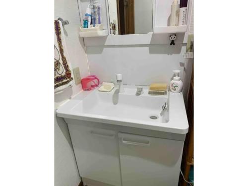 a bathroom with a white sink and a mirror at Family House "2F" - Vacation STAY 12940 in Kumamoto
