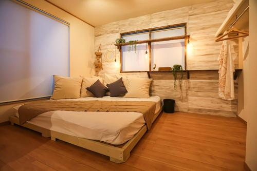 a bedroom with a bed with a wooden wall at NAGI - Vacation STAY 41896v in Nanjo