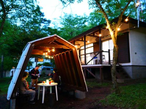 a group of people sitting at a table in front of a house at Minamitsuru-gun - Cottage - Vacation STAY 96482v in Yamanakako