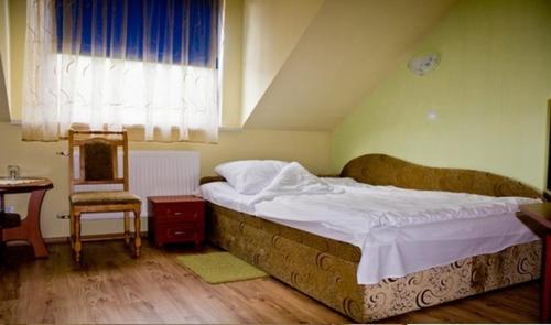 1 dormitorio con 1 cama, 1 mesa y 1 silla en Hotel Czardasz, en Września