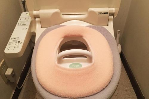 a toilet with a pink seat in a bathroom at Umimachi Seikatsu Koshigoe Minatokan - Vacation STAY 55291v in Kamakura