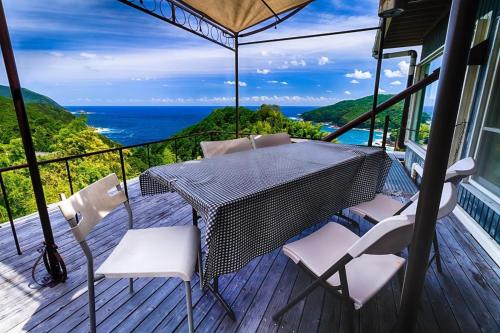 a table and chairs on a deck with a view of the ocean at Tennyoza Entertainment Guest House - Vacation STAY 13010 in Kumano