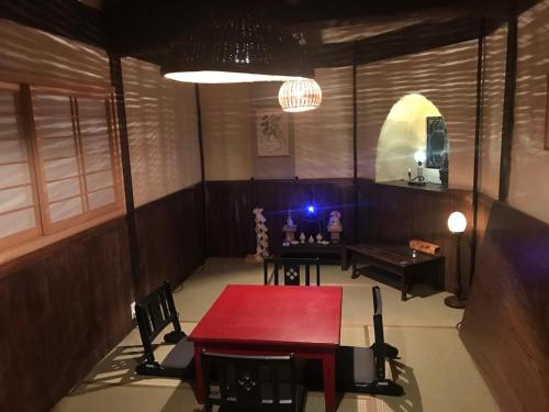 a room with a red table and chairs in it at Tennyoza Entertainment Guest House - Vacation STAY 13010 in Kumano