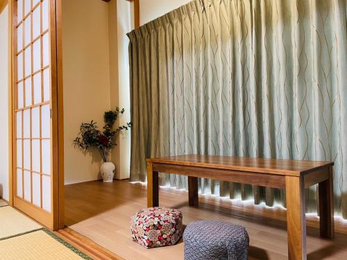 a table and a stool in a room with a curtain at HOSTEL UKS - Vacation STAY 13007 in Nagoya