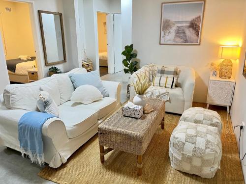 a living room with a white couch and a table at Urban Beachside Escape near Eastgardens in Sydney