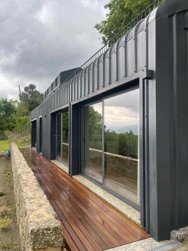 a house with large windows on a wooden deck at Quinta Cerca da Milhera - Unique Experiences by LuxiStay in Ponte da Barca