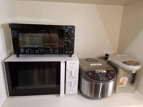 a microwave sitting on top of a toaster oven at Nagatoro fireplace - Vacation STAY 59551v in Minano