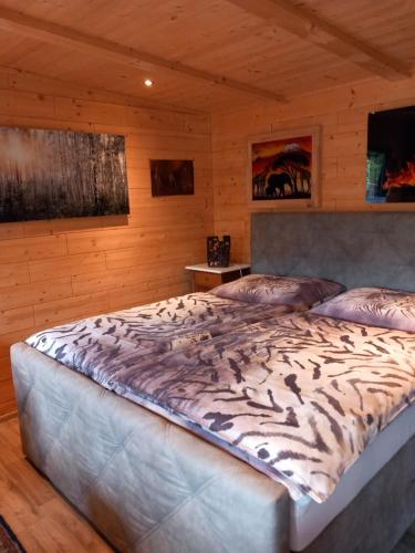 a large bed in a room with wooden walls at Alm-Chalet in der Nähe vom Klippitztörl 