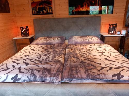 a bedroom with a bed with a blanket and two night stands at Alm-Chalet in der Nähe vom Klippitztörl 