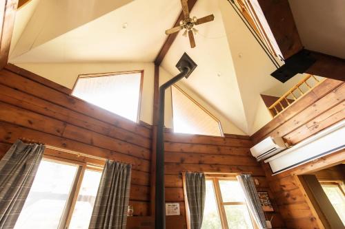 a room with wooden walls and windows and a ceiling at Log House Kizuki - Vacation STAY 62486v in Tsuru 