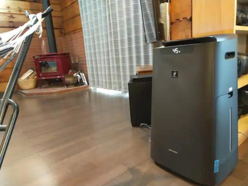 a small refrigerator in a room with a stove at Log House Seseragi - Vacation STAY 62500v in Tsuru 