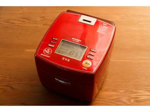 a red electronic device sitting on top of a table at Log House Seseragi - Vacation STAY 62500v in Tsuru 