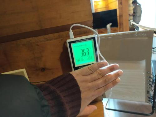 a person holding a digital clock in their hand at Log House Seseragi - Vacation STAY 62500v in Tsuru 