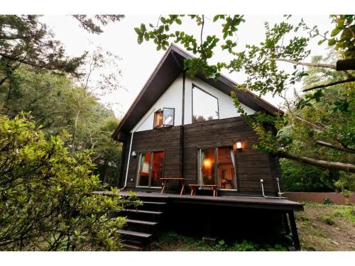 a small house with a deck in the woods at Log House Seseragi - Vacation STAY 62500v in Tsuru 