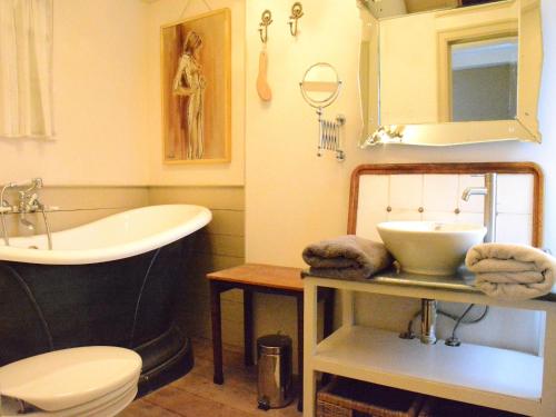 a bathroom with a tub and a sink and a toilet at Holiday home in Bièvre near town center in Bièvre