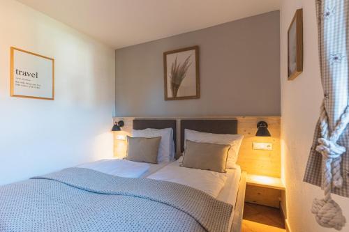 une chambre avec un lit avec des draps et des oreillers bleus dans l'établissement Dorfchalets - Chalet Dora inkl Tauern Spa Eintritt & Sommerkarte, à Kaprun