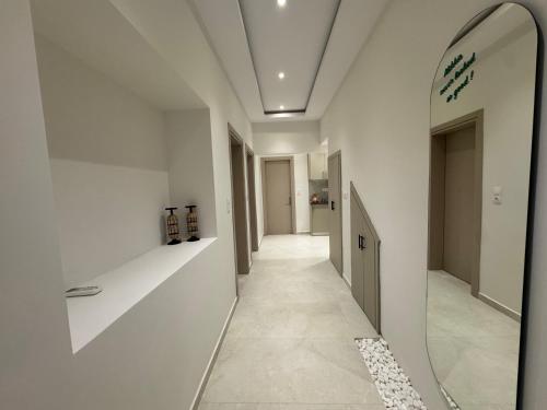 a hallway with white walls and a mirror on the wall at ALIKKIS The Boutique Stay Experience in Stavros