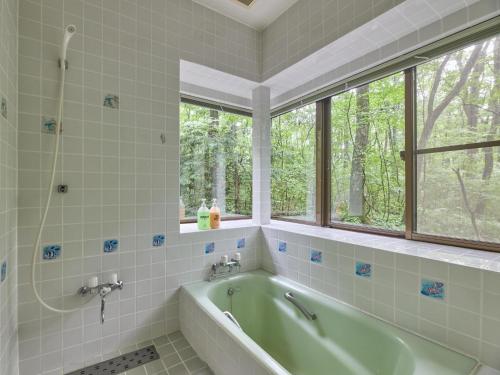 a bathroom with a tub and a window at Runesu Karuizawa - Vacation STAY 92239v in Tsumagoi